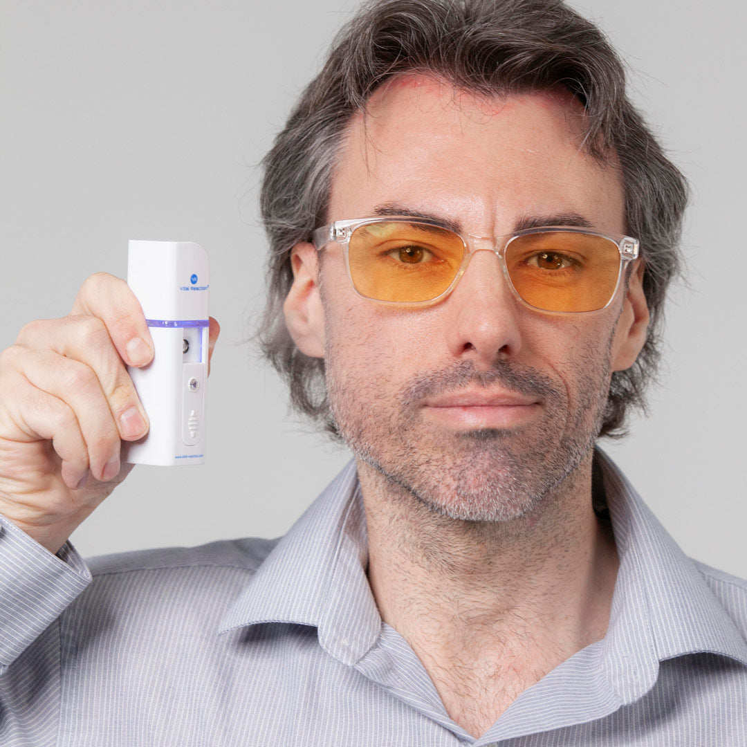 man wearing glasses holding vital reaction H2 dermal therapy device