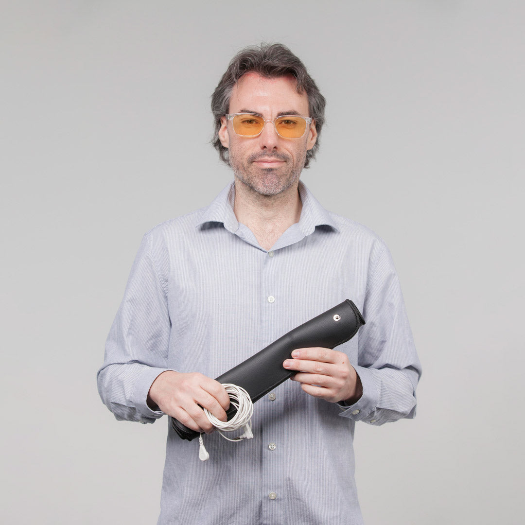 man wearing glasses holding vital reaction grounding mat