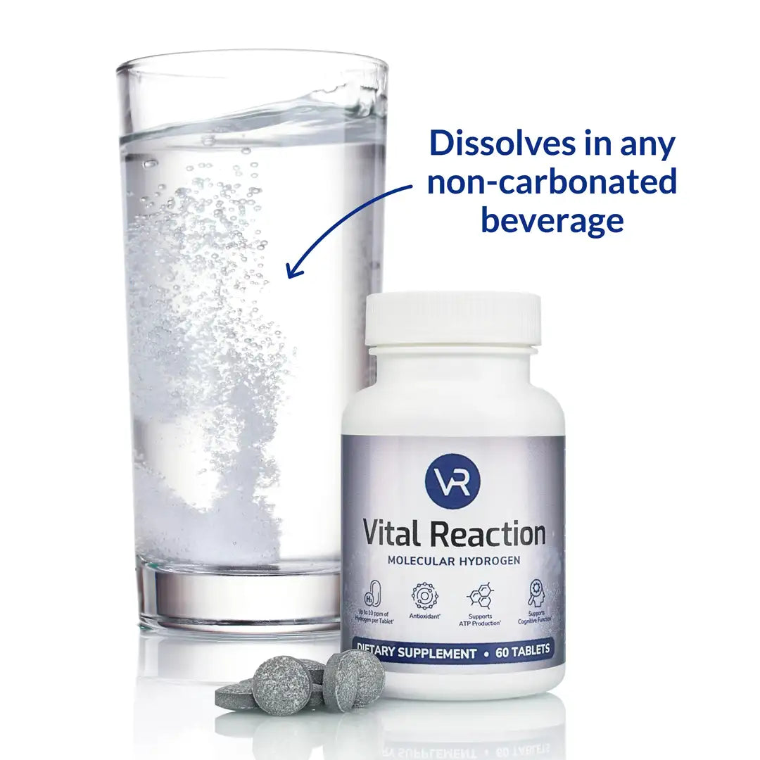 H2 tablets dissolving in a glass of water behind a bottle of vital reaction molecular hydrogen tablets